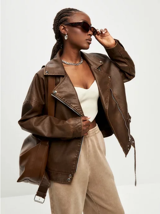 женщина в стильной кожаной куртке оверсайз